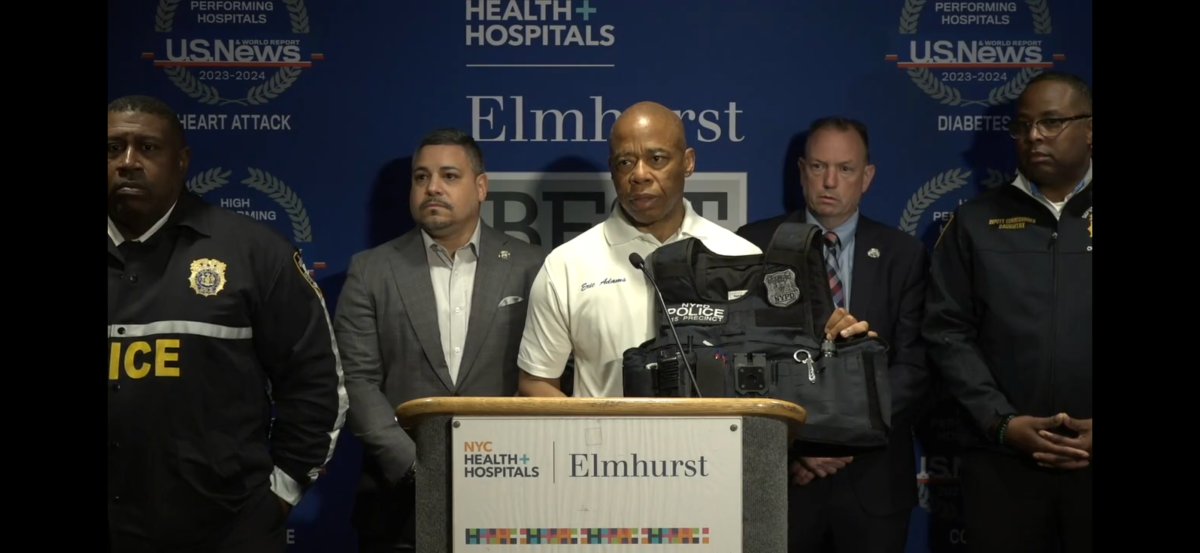 Mayor Eric Adams holds a bulletproof vest during press conference