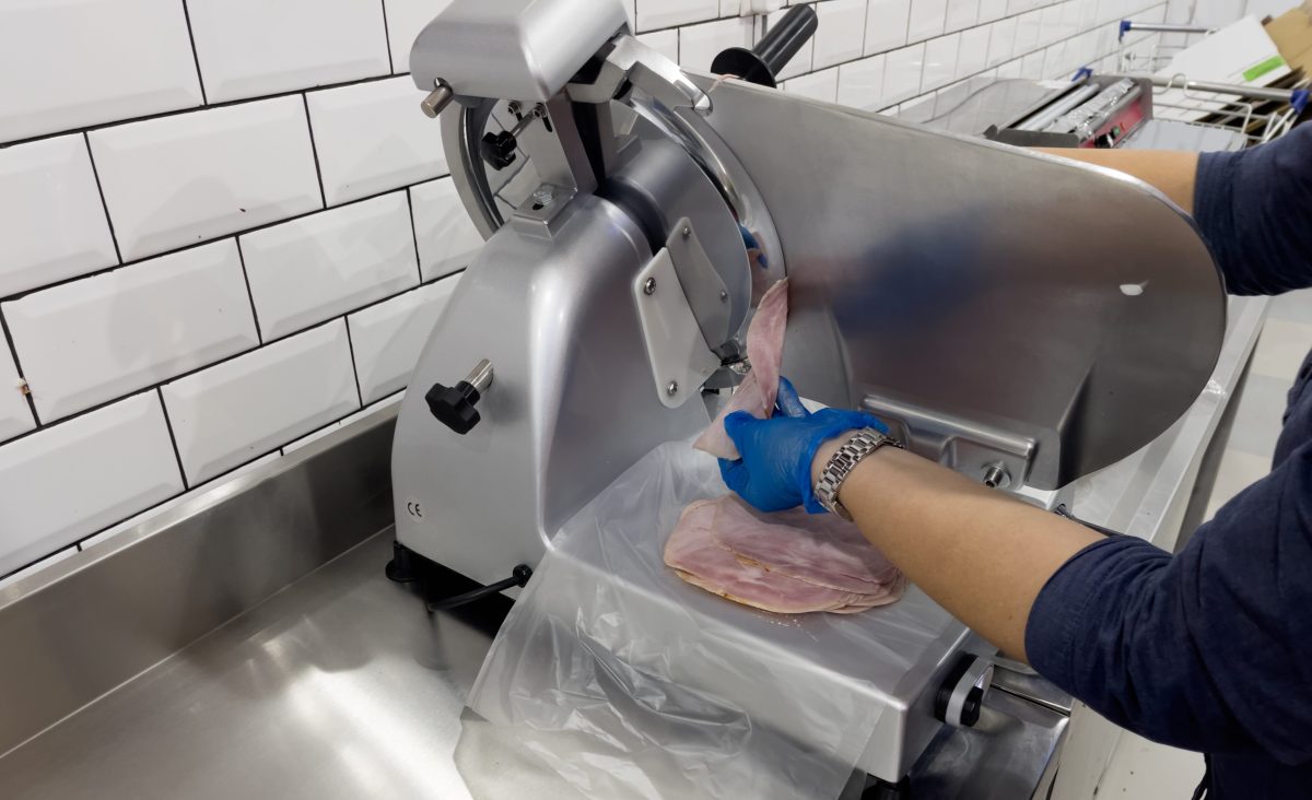 Person slicing Boar's Head cold cuts