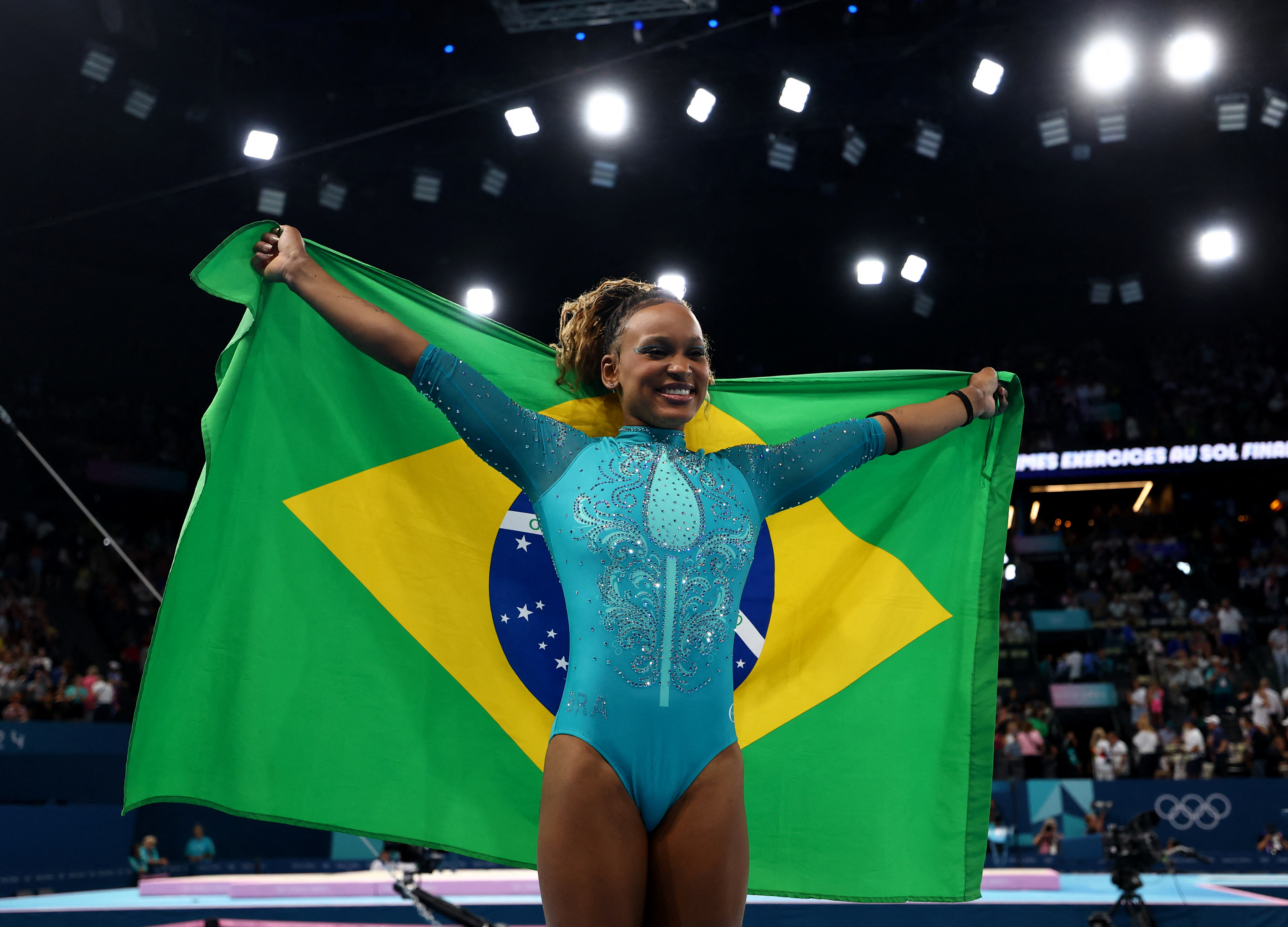 Olympics 2024: Simone Biles fights through injury, earlier fall on beam to take silver in floor excercise 3 Paris 2024 Olympics - Artistic Gymnastics - Women's Floor Exercise Final - Bercy Arena, Paris, France - Rebeca Andrade of Brazil celebrates with her national flag after winning gold.