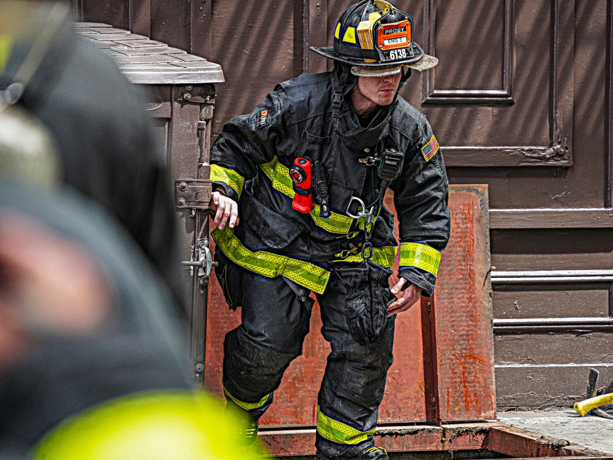 A firefighter emerges from the basement