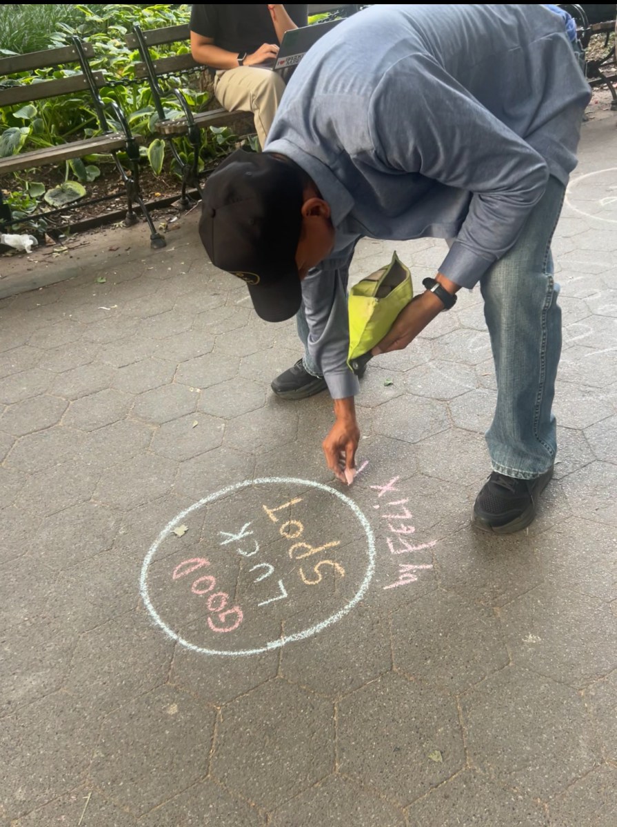 Looking for good luck? How chalk circles are taking over Washington Square Park 2 Felix Morelo drawing a good luck spot in Washington Square Park.