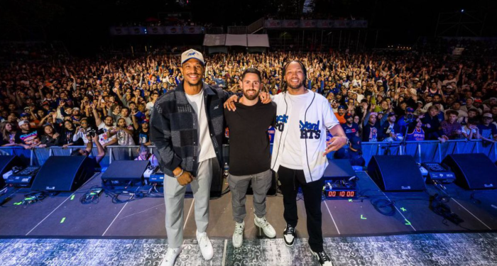 Jalen Brunson Josh Hart Roomates Block Party: Three men stand in front of large crowd in Central park