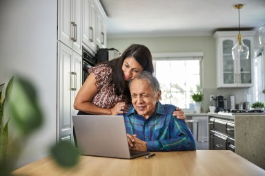 Daughter assisting father on how to use the computer