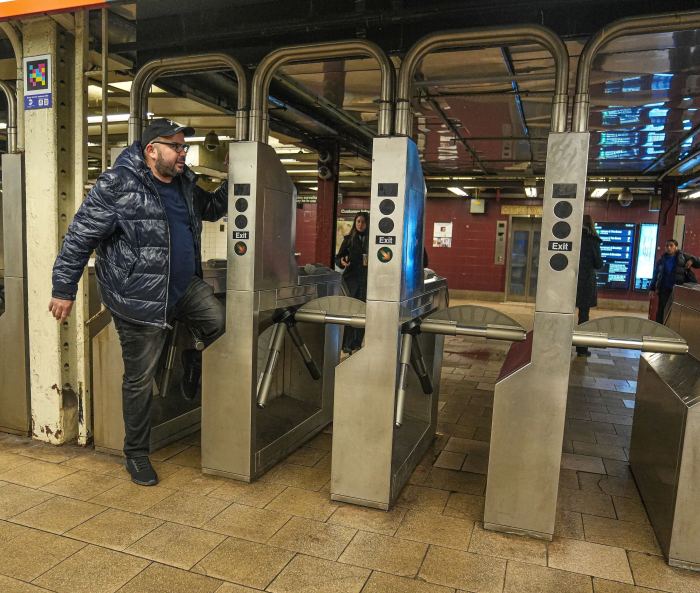 a man doing fare evasion through a turnstile 