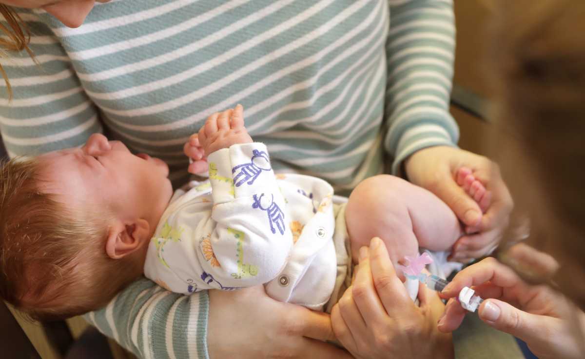 Young baby crying while getting vaccinated against measles