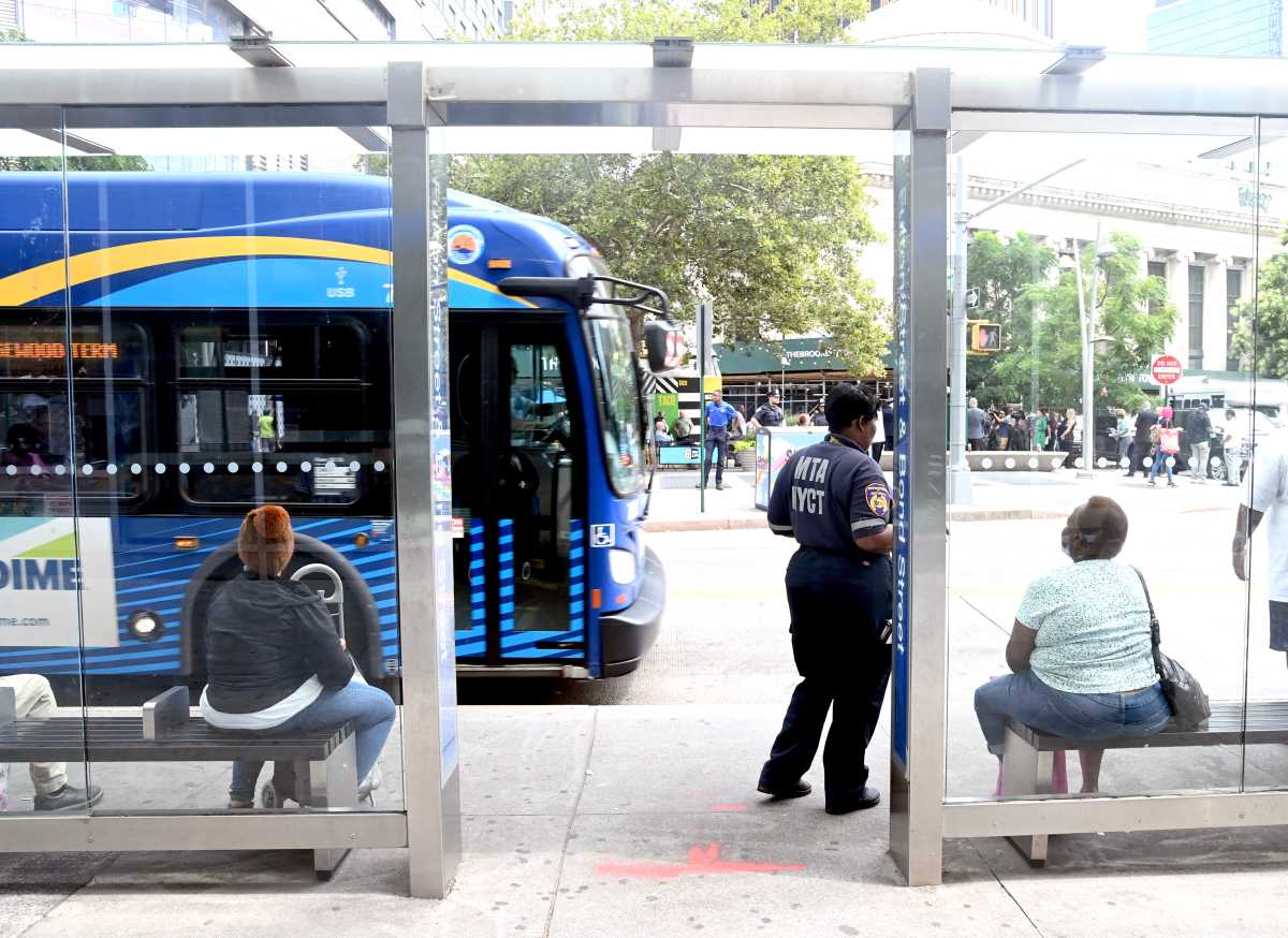 People sitting at a bus stop shelter