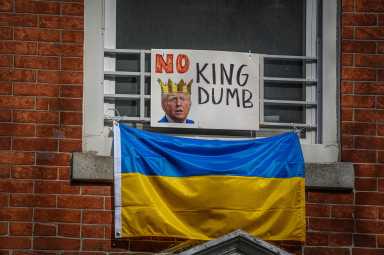 Ukrainian flags can be spotted plastered across glass and hanging from window sills with photos of Trump reading “No kings.” Other banners read: “abort Prez Musk.”