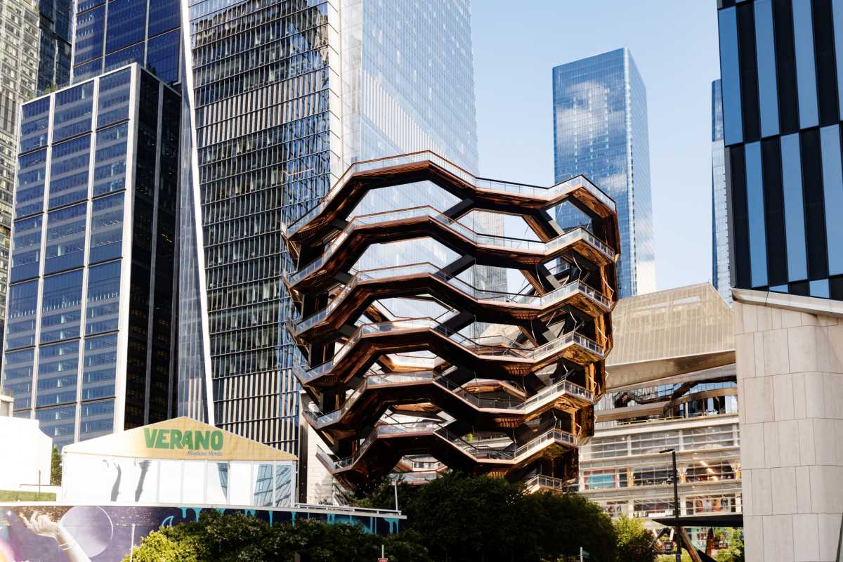 August 20th, 2024 - New York City, NY, USA: The Vessel architecture stands prominently in front of the other modern skyscrappers in Hudson Yards on a sunny afternoon in summer.