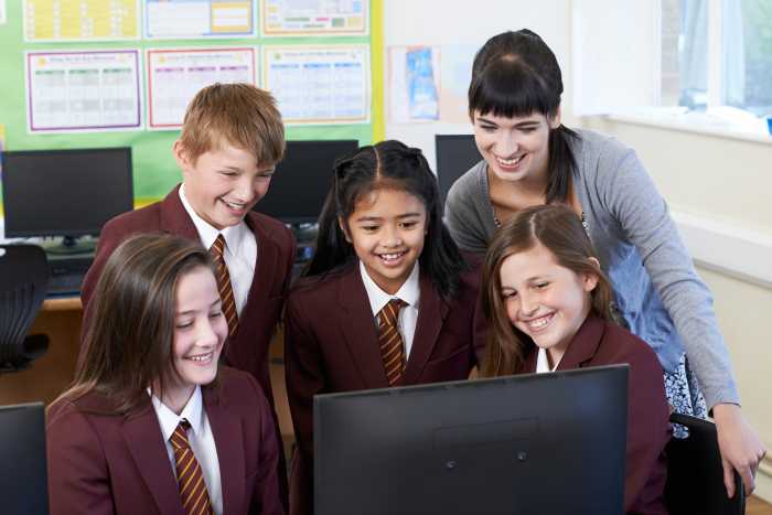 Students in nyc charter school classroom looking at computer