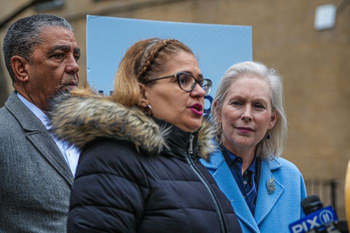 New York pols rally to keep Social Security off the DOGE chopping block 3 woman in a black coat flanked by a man and a woman