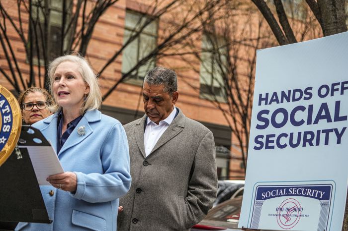 people standing at a podium outside talking about Social Security