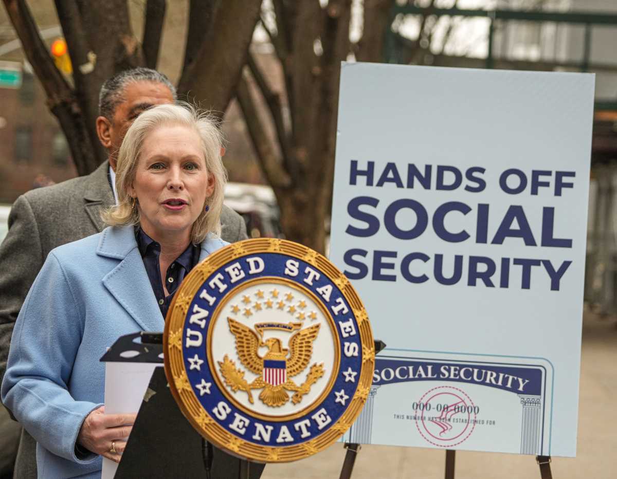 woman at a podium at a rally in New York to protect Social Security