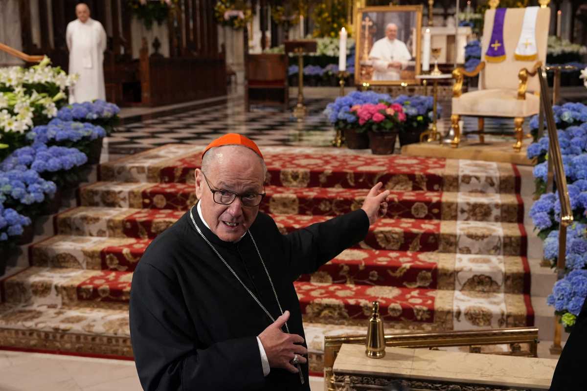 Cardinal Dolan points to an image of Pope Francis on the altar of St. Patrick's Cathedral 