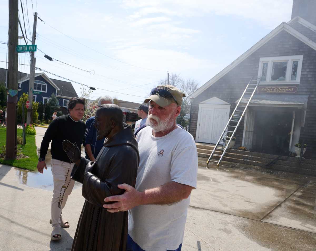Three-alarm fire in Queens guts church hours before Easter celebrations 3 Parishioner carries statue out of Queens church during fire