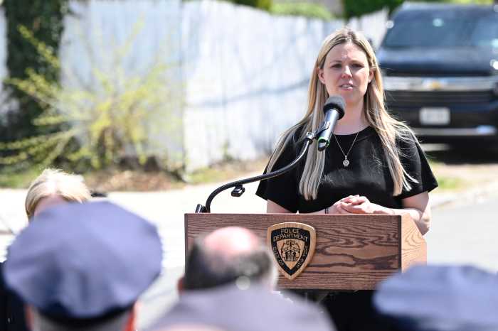 NYPD unveils memorial at new Queens precinct honoring officer shot dead last year 3 woman standing at an outdoor podium
