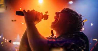 Energetic Rock Band Performing on a Nightclub Stage with Dynamic Lights and Special Effects. Portrait of an Artist Creating a Unique Show Experience With Powerful Alternative Songs