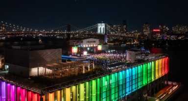 Rooftop at Pier 17 lit up in rainbow colors during concert