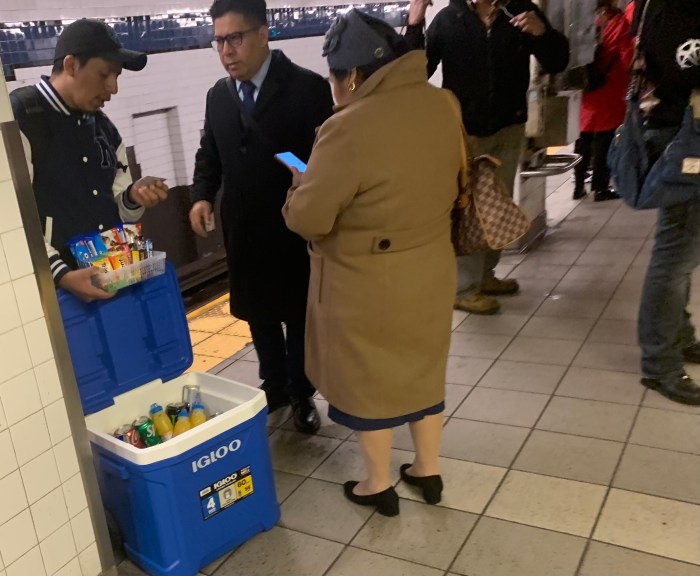 a many selling snacks on a subway platform in one of many NYC subway stations