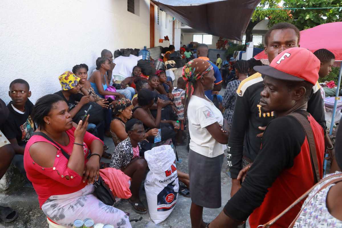 Haitian refugees stand on line at a camp