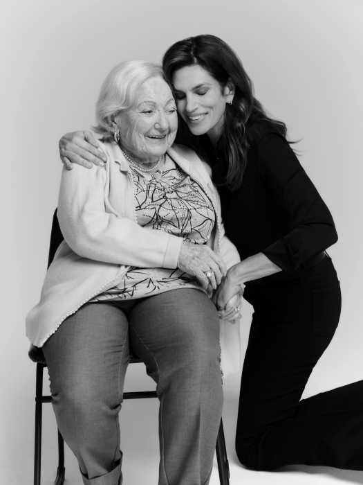 a woman sitting in a chair with another woman kneeling next to her