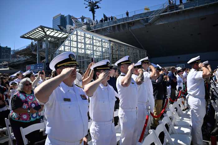 Navy members salute on Memorial Day at the Intrepid Sea Air and Space Museum