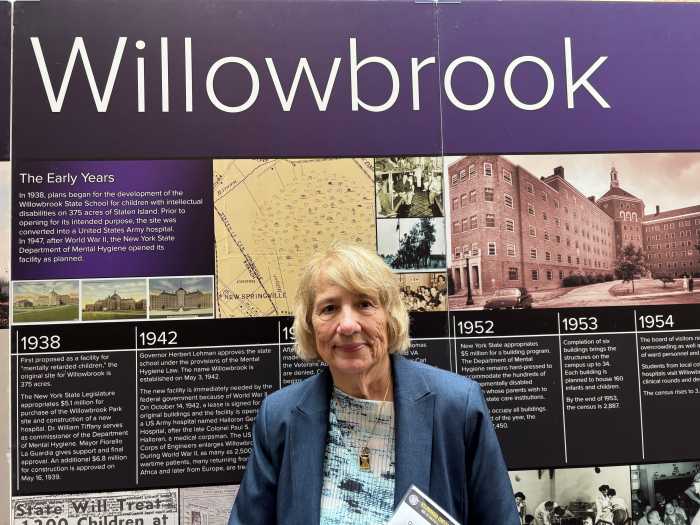 'Never go back!' Hundreds united on Staten Island for 50-year celebration of Willowbrook State School closure decree 2 woman standing in front of exhibit marking history of Willowbrook State School