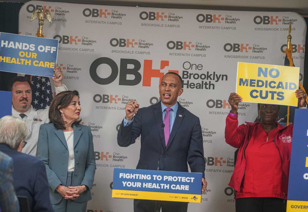 Hakeem Jeffries and Kathy Hochul speak with people holding signs against medicare and medicaid cuts