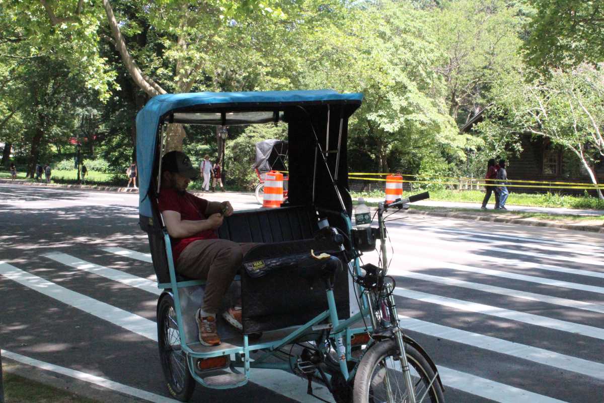 NYC bakes in first major heat wave of 2025, but not everyone feels the heat equally 2 a man seeks shade in a peddycab in new york city during a heat wave