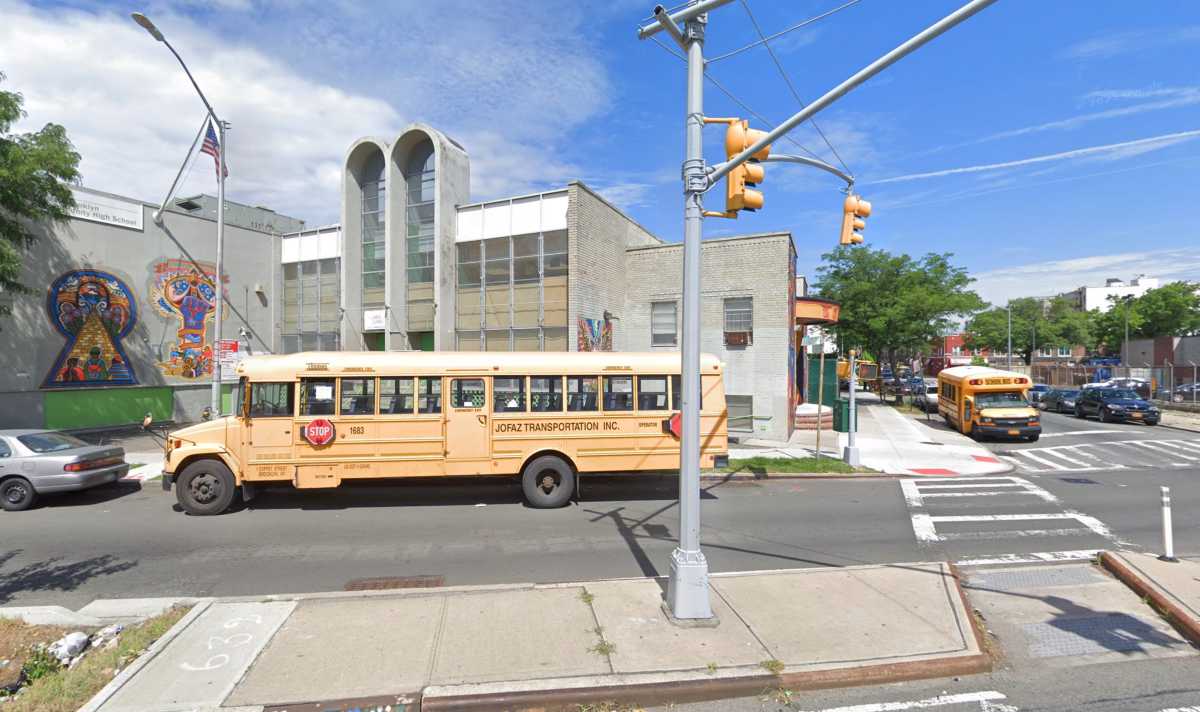 school bus and stop light in front of school building
