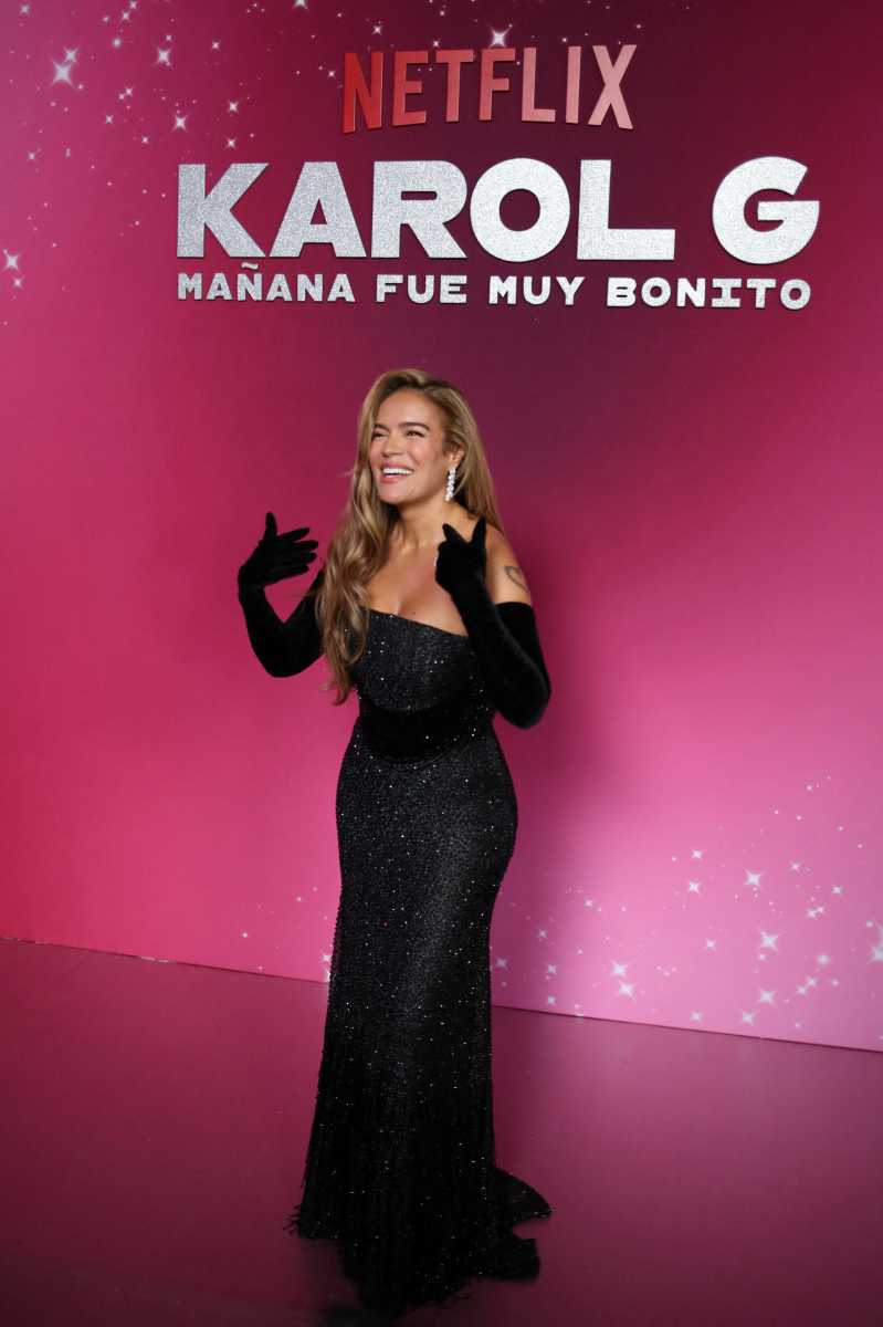 woman in black dress and gloves on red carpet of Karol G premiere