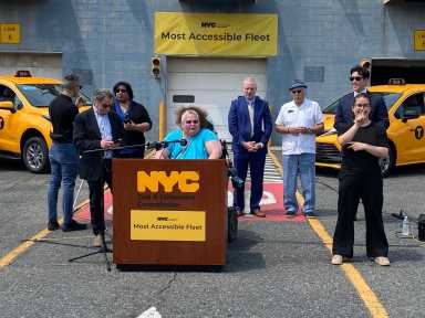 people outside at a podium at NYC taxis facility