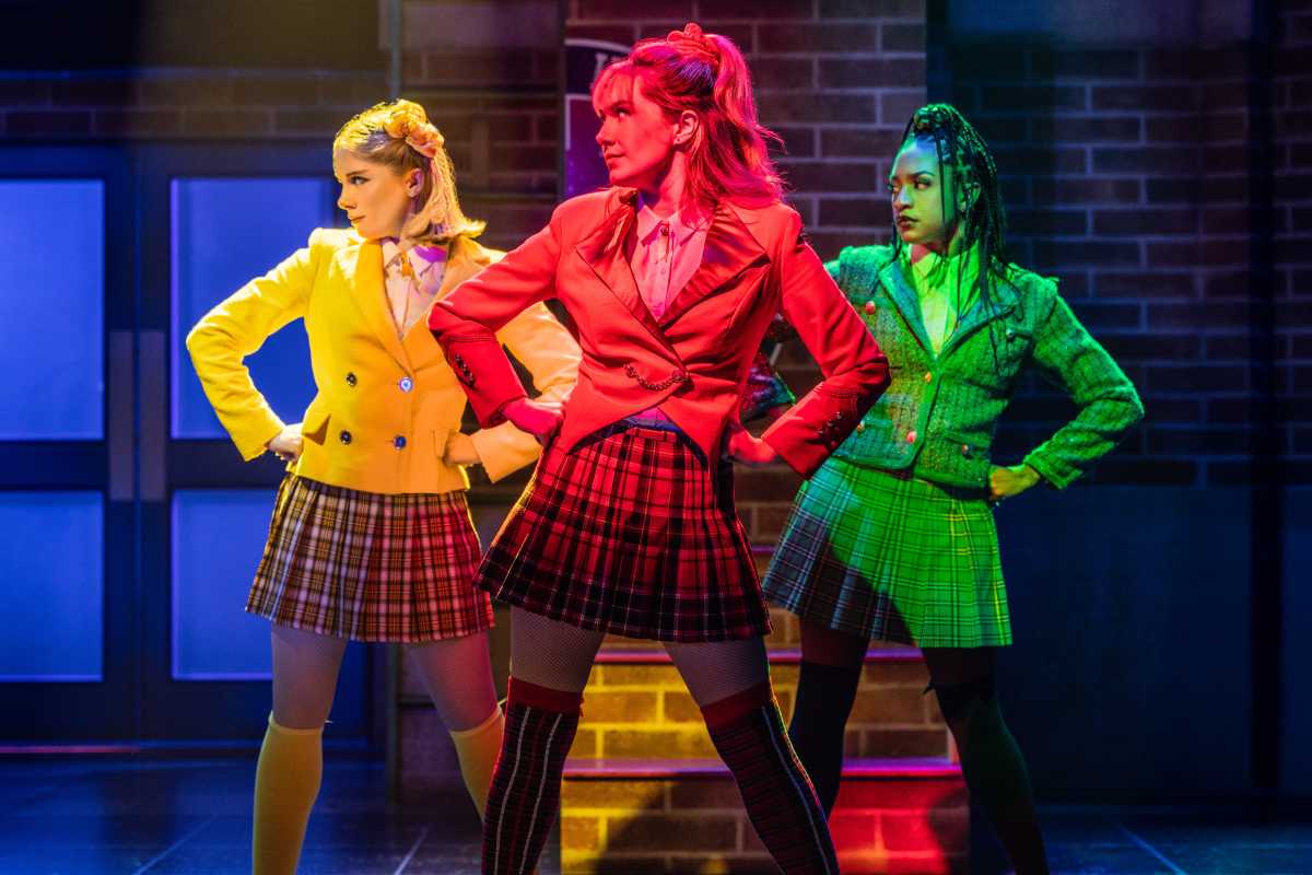 three women set in yellow, red and green broadway lighting