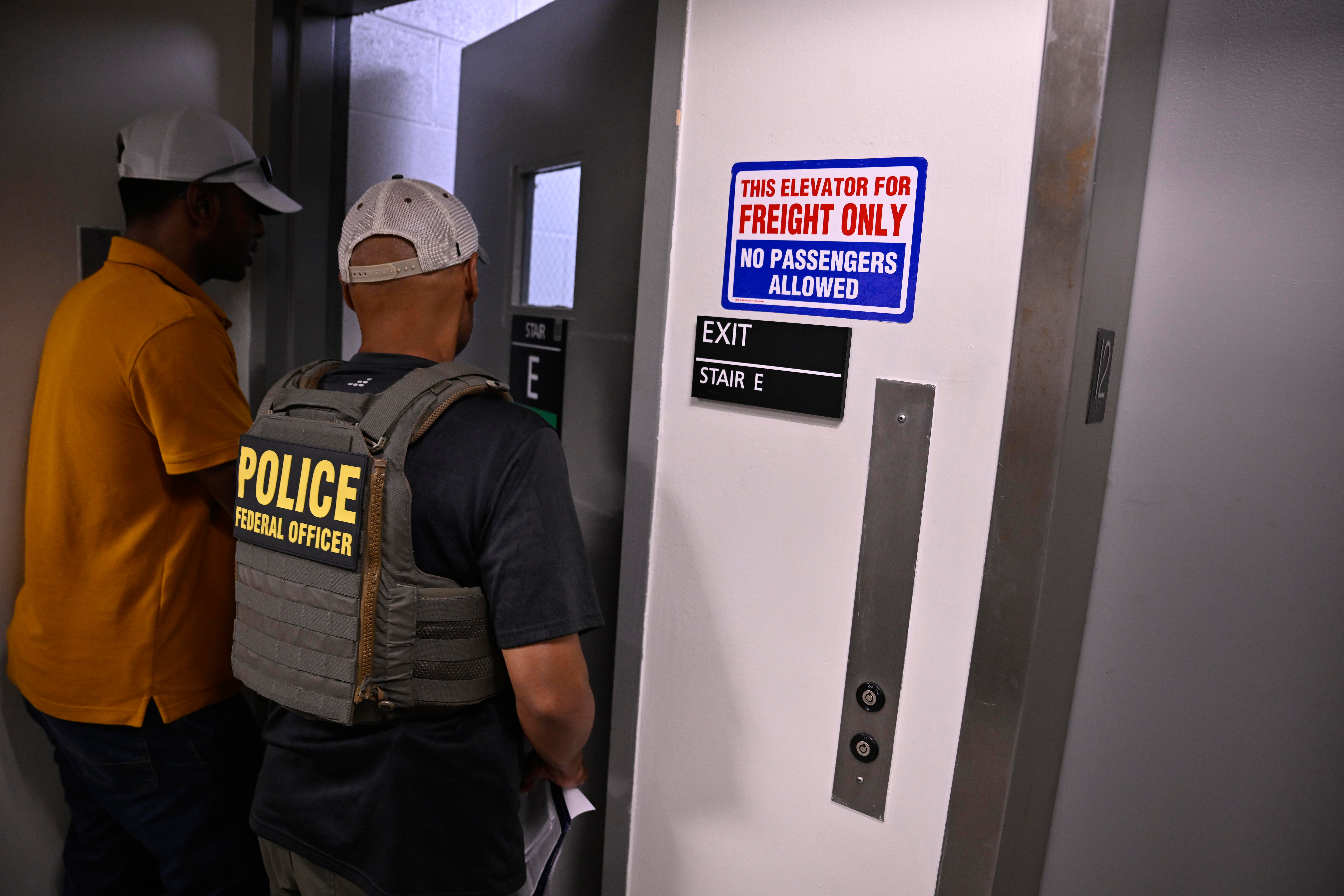 A ICE Agent takes a man in for questioning on July 10.