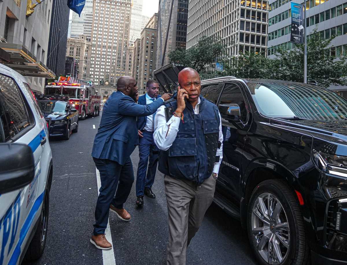 Man on phone in vest talking at crime scene mayor eric adams