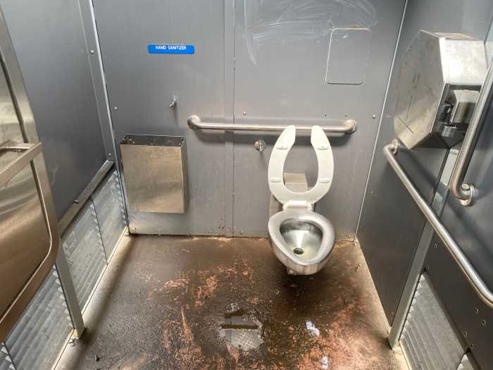Mud clogs the drain inside the Portland Loo at Irving Square Park, creating swamp-like conditions
