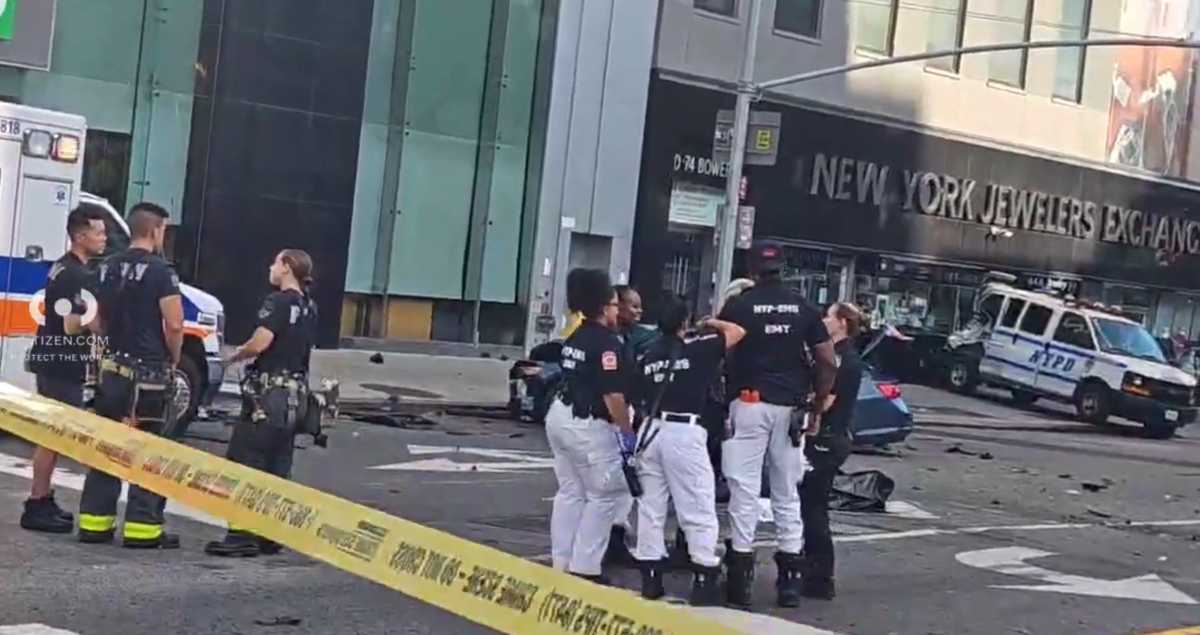 people in blue and white shirts investigate hit-and-run crash in Chinatown with yellow police tape nearby and vehicle debris on ground