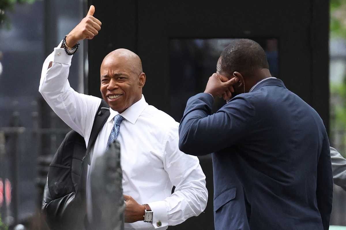 man in white shirt and gray tie holds thumbs up gesture in air