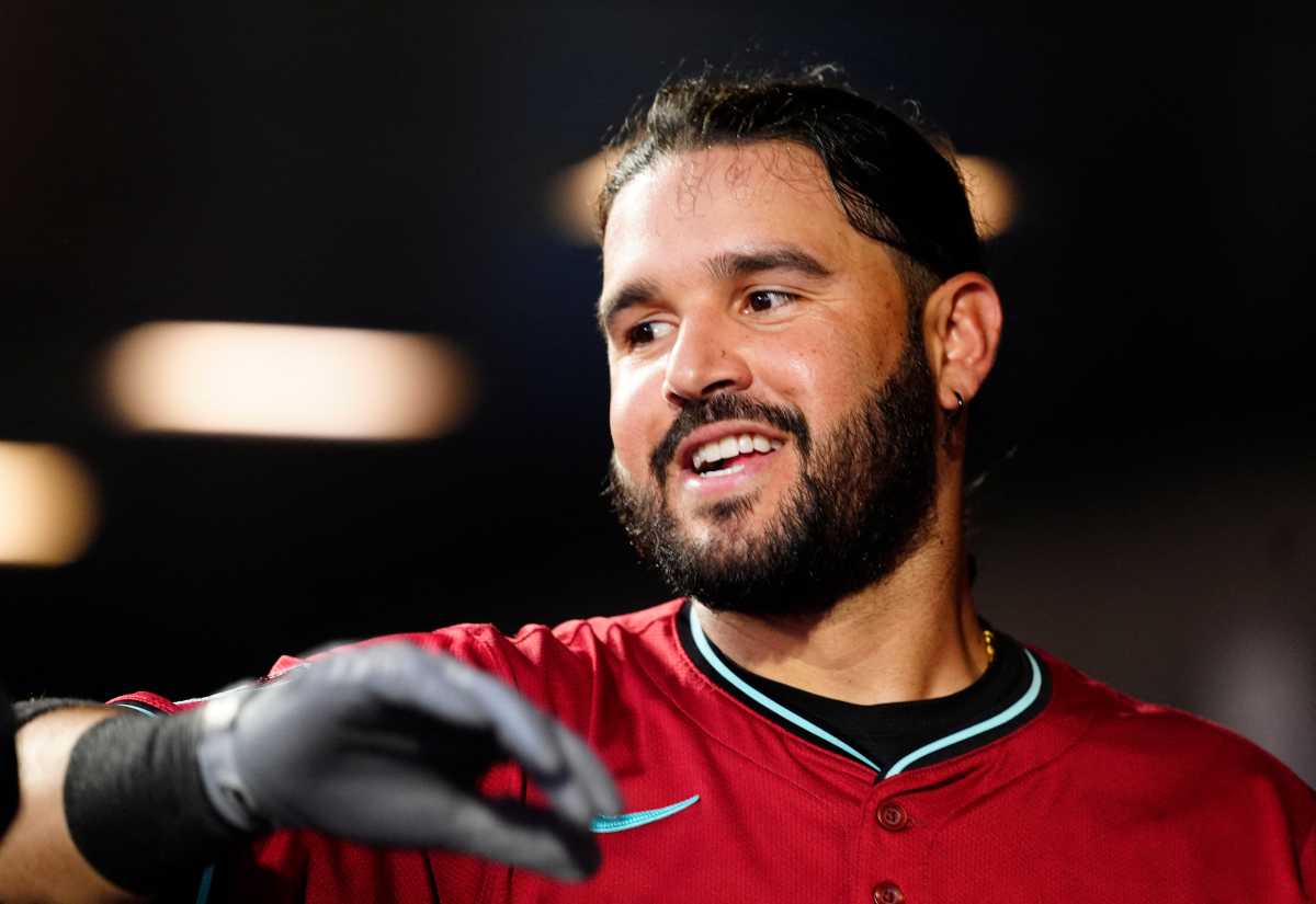 Eugenio Suarez: Man in red baseball jersey smiles and high-fives teammate
