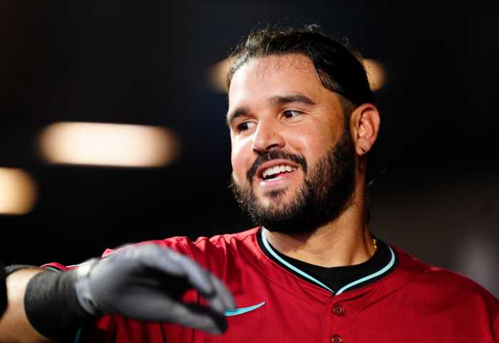 Eugenio Suarez: Man in red baseball jersey smiles and high-fives teammate