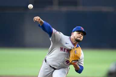 Frankie Montas Mets pitcher in gray uniform and blue hat throws baseball