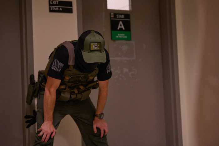 ICE in courts: More immigrants cuffed at Federal Plaza as even officers feel the strain 4 a law enforcement officer in uniform with his hands on his knees