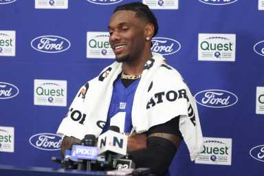 giants player with white towel around his neck in front of blue background