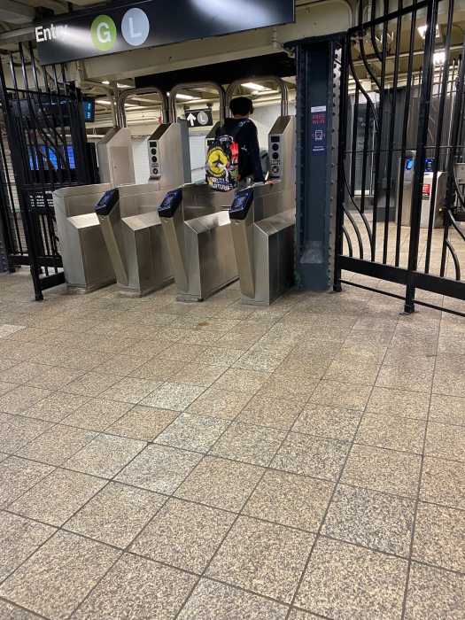 Fare evasion: A Brooklyn subway station becomes a hotbed for bold people cheating the system 2 person wearing black jumps over a turnstile