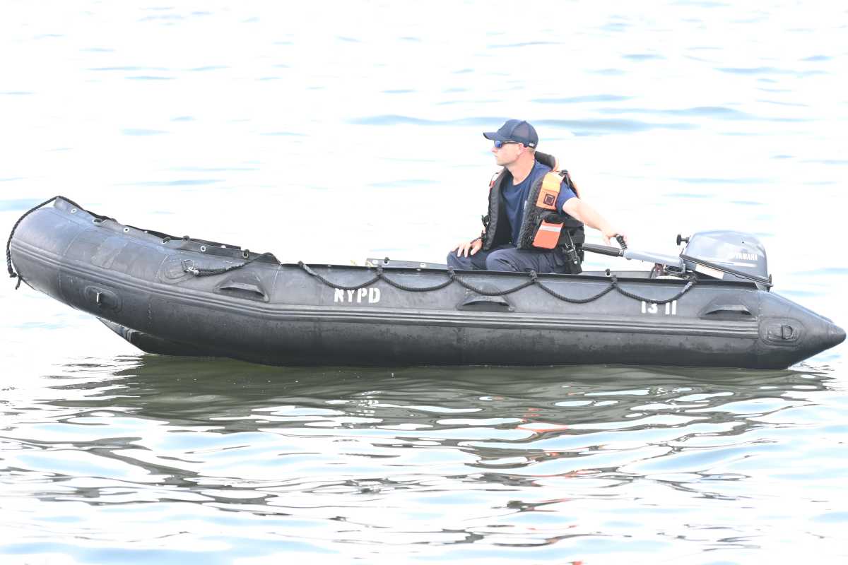 A person in an black NYPD dingy on the Hudson River