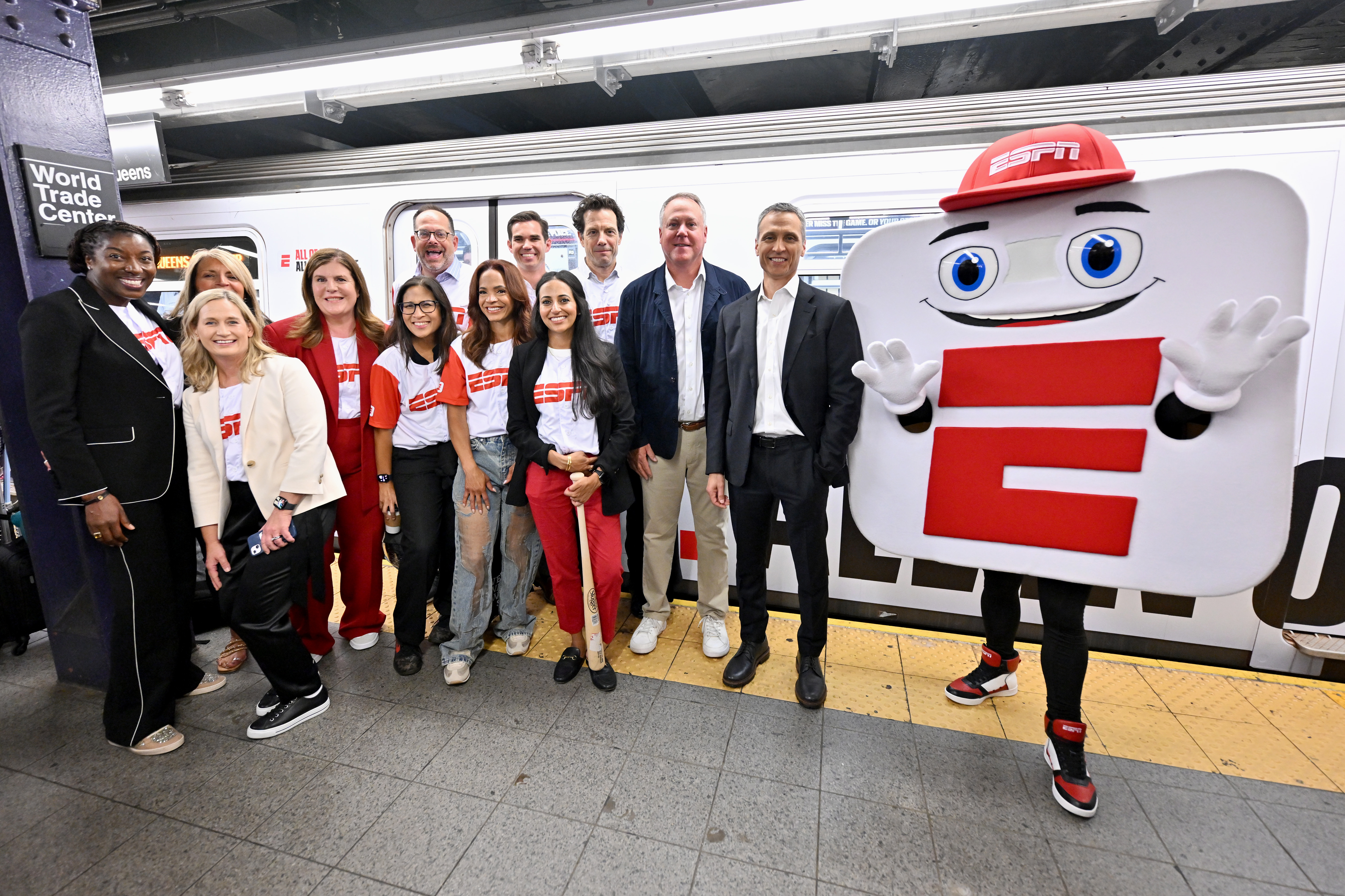 Rosalyn Durant, Denise Pellegrini, Tina Thornton, Rita Ferro, Judy Agay, Josh Krulewitz, Elle Duncan, Jimmy Zasowski, Chara-Lynn Aguiar, Adam Smith, Burke Magnus, ESPN Chairman Jimmy Pitaro and mascot App-E take the inaugural ride of ESPN’s "E" train takeover celebrating the launch of the new ESPN app on August 21, 2025 in New York City. 