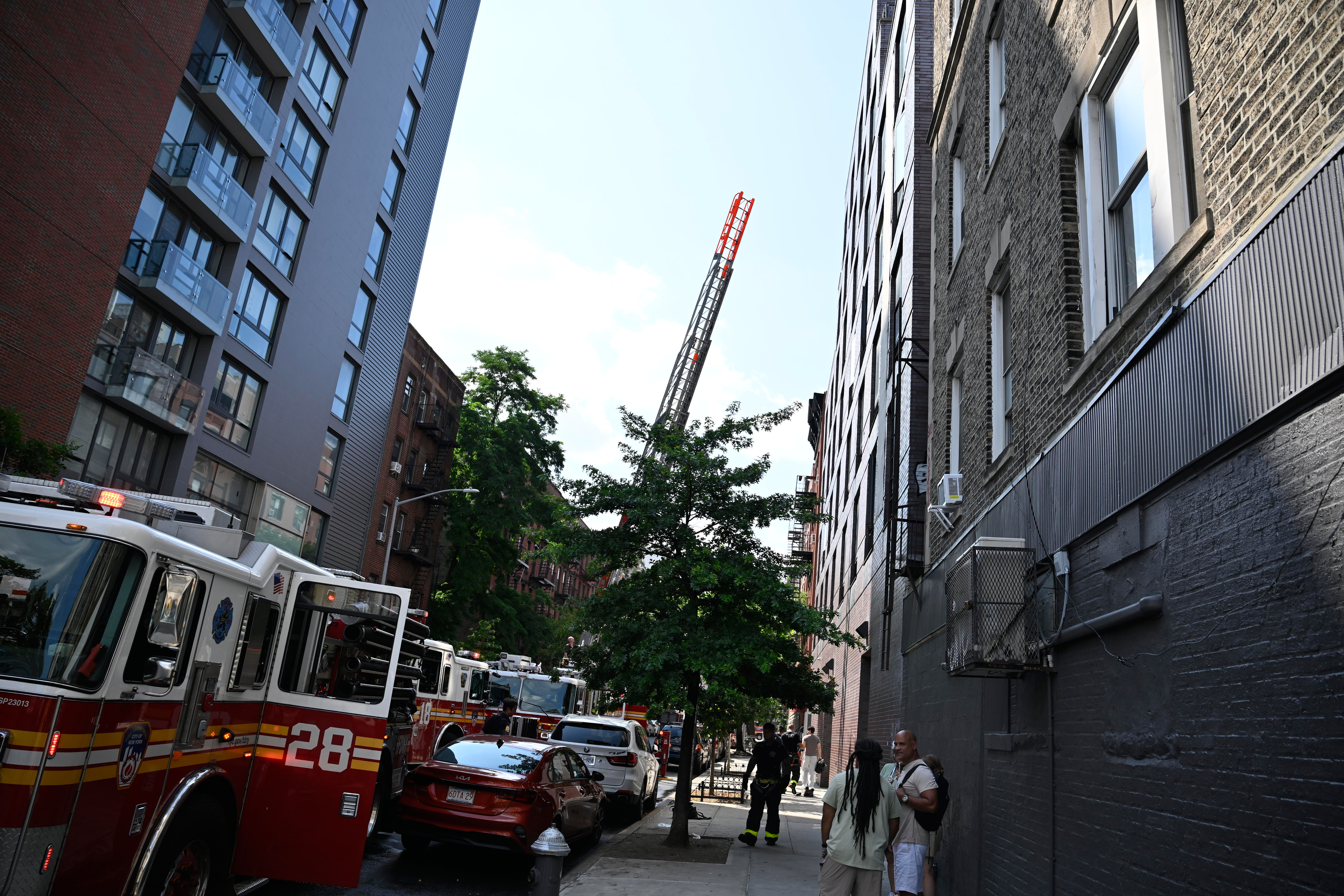 A firefighter works to beat the heat as temps were in the mid 90's during an afternoon blaze in the lower East side on Monday, July, 28.