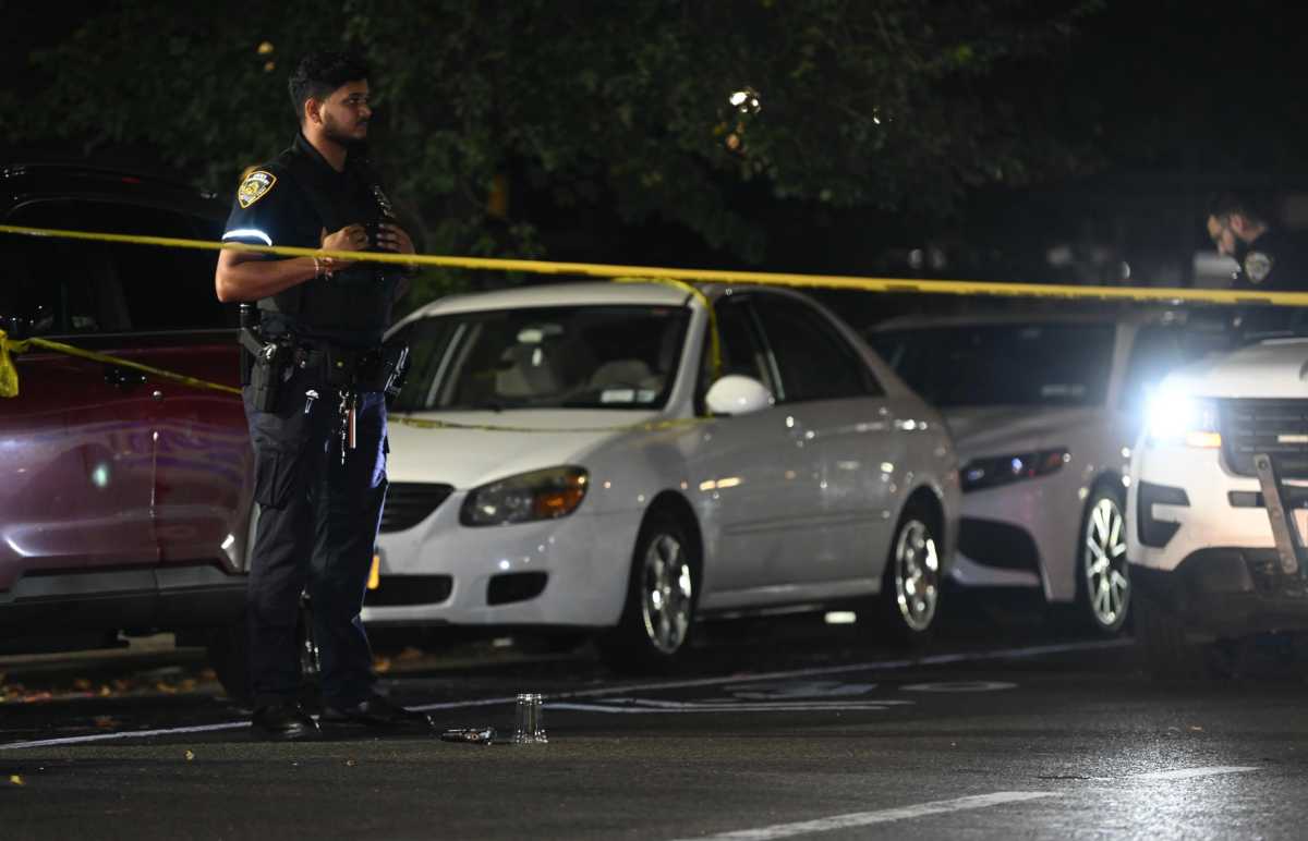 cop at shooting scene with police tape stretched across street