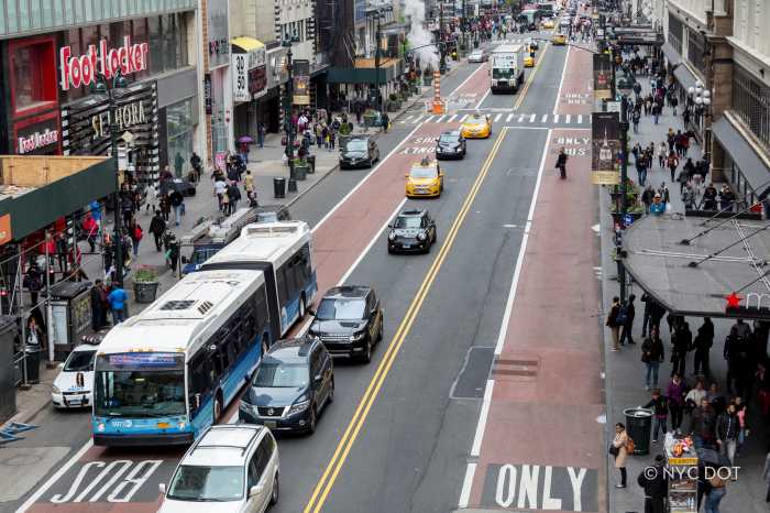 a busy street with cars, buses and pedestrians