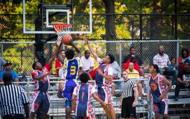 Players compete at a basketball game at historic Rucker Park in Harlem.