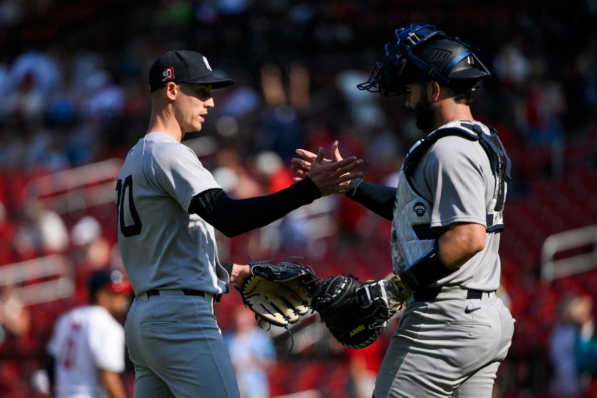 Yankees pitcher and catcher in gray uniforms shake hands after final out.